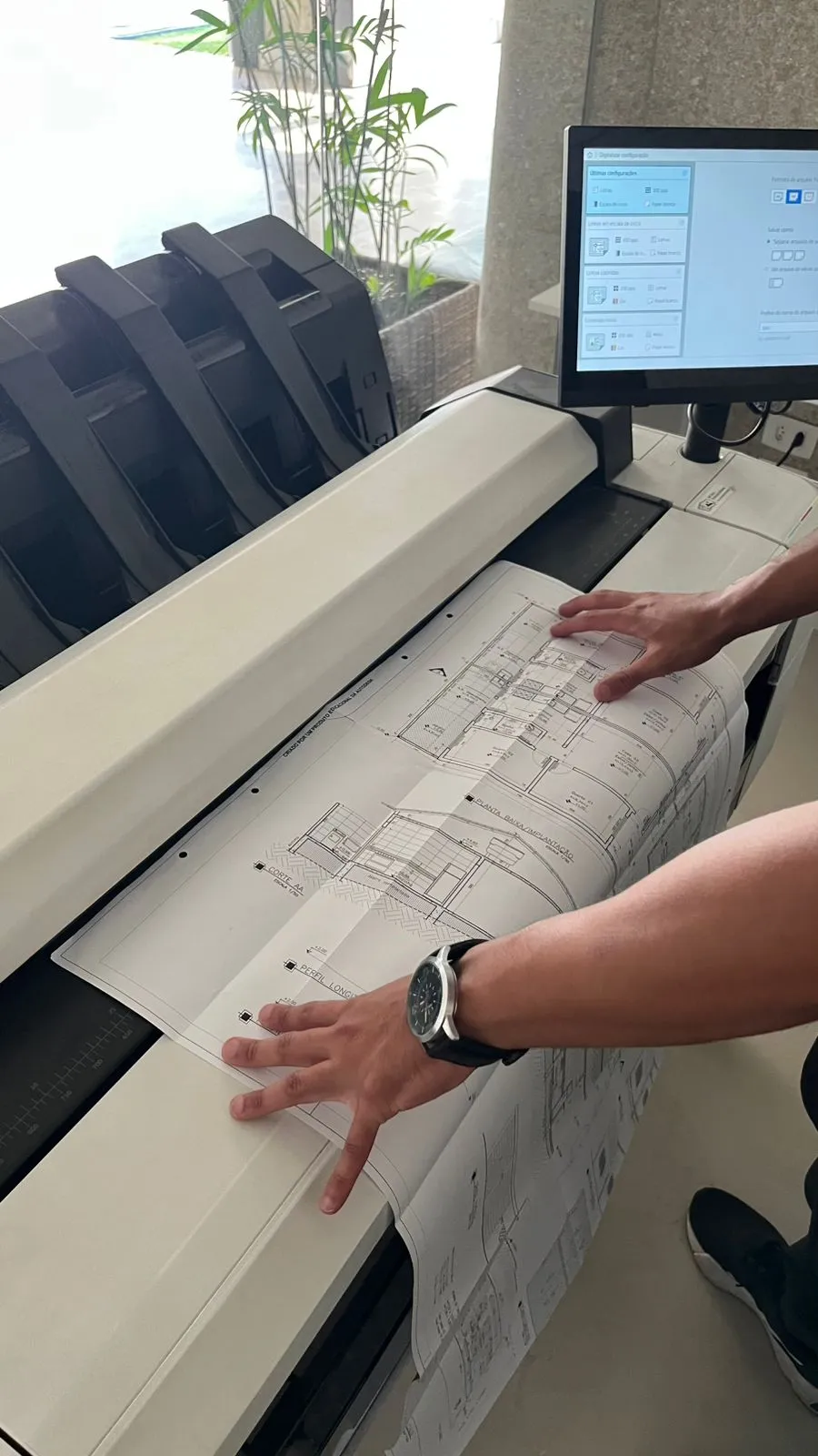 Operador digitalizando planta técnica em scanner de grande formato A0 na CEDOC