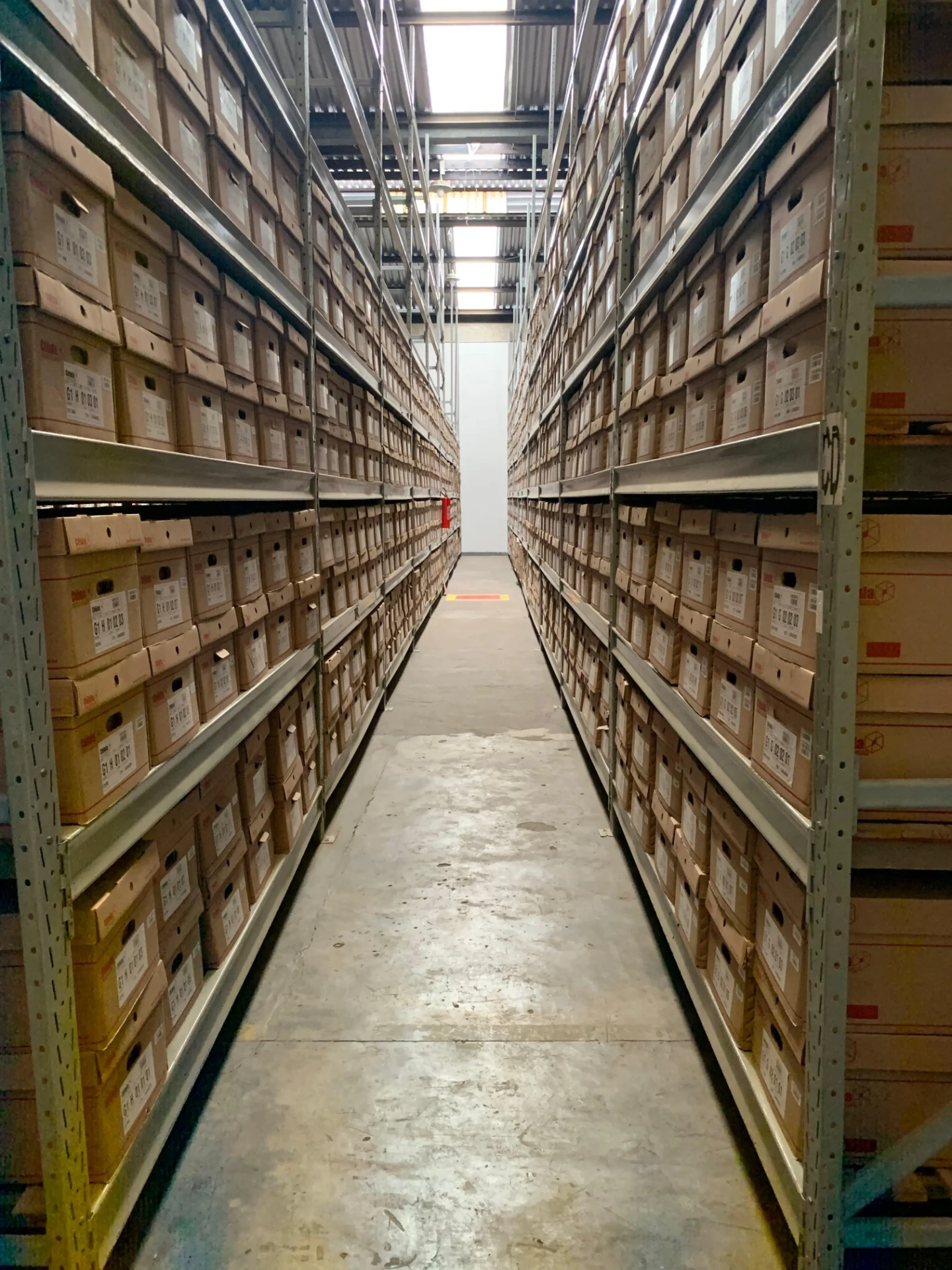 Galpão da CEDOC com estantes porta-pallets organizando caixas de documentos